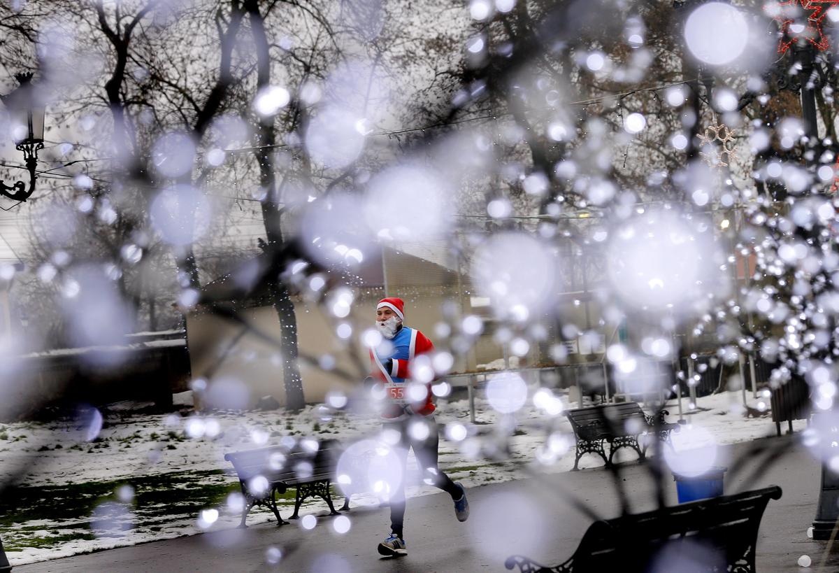 Một người đàn ông Romania trong bộ phục trang ông già Noel đang tham gia một cuộc thi chạy gây quỹ từ thiện tổ chức ở thành phố Bucharest, Romania.