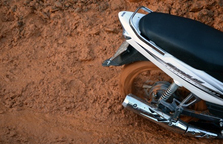 Một người cố gắng dắt xe máy qua điểm sạt lở nhưng không được nên phải huy động người bưng.