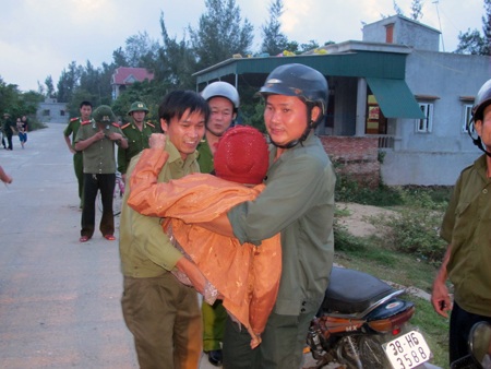   Lực lượng dân phòng của xã bế các cụ già lên xe đi tránh bão.