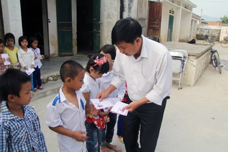 Grobest Industrial Việt Nam trao 40 suất quà đến học sinh nghèo vùng lũ - 6 Anh Lê Văn Thành - Bí thư Đảng ủy xã Quỳnh Vinh trao quà tới các em học sinh nghèo của trường.