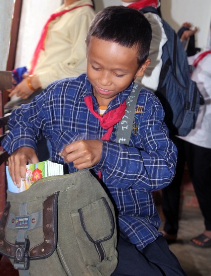 Niềm vui của một học sinh khi nhận được vở viết.