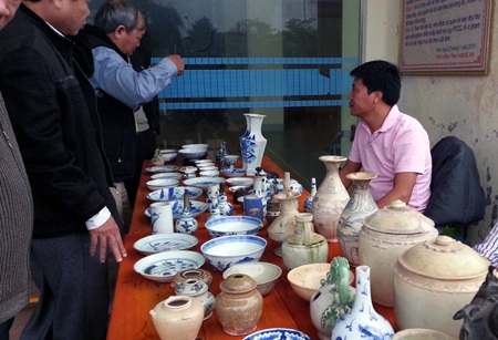 Một nhà sưu tầm cổ vật đang xem chiếc bát đời Thanh có giá 6 triệu.