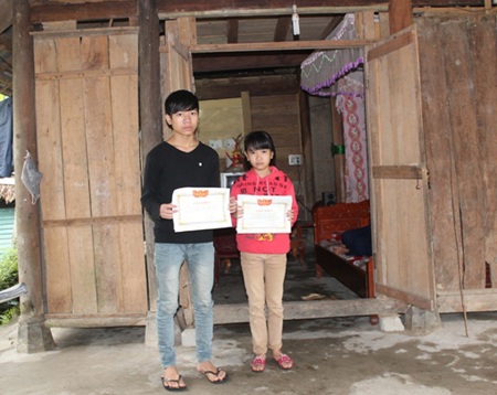 Hai anh em Thắng và Đan Thùy trước căn nhà đã cũ nát của ba bác cháu.