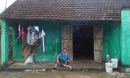 Gia đình Nguyễn Hữu Chút trước căn nhà tồi tàn của mình.   