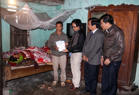 Ông Lê Đức Cường cùng cán bộ huyện và cán bộ ngân hàng làm thủ tục gửi tiền.