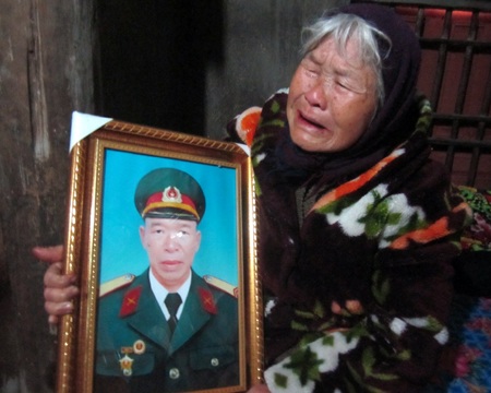 Ôm tấm di ảnh của con trai, cụ Nguyễn Thị Đừng khóc ngất đi.