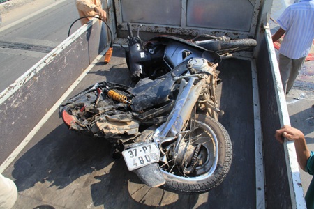 Chiếc xe máy của vợ chồng ông Sử nát bét sau khi bị xe tải ben kéo dài.