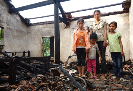 Mẹ con chị N. đứng trong ngôi nhà toàn gỗ cháy đen, không còn một thứ gì.