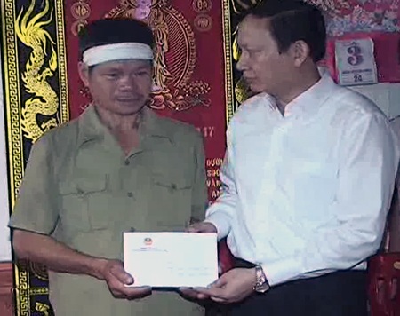 Đồng chí Lương Hồng Quang trao quà Chủ tịch nước 20 triệu đồng tới gia đình em Nam (Ảnh: H.K).