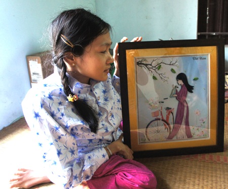 Nga bên bức tranh ghép từ những sợi giấy.