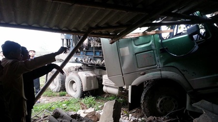 Chiếc xe đầu kéo mất lái lao vào nhà dân sau vụ tai nạn.