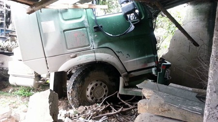 Chiếc xe đầu kéo mất lái lao vào nhà dân sau vụ tai nạn.