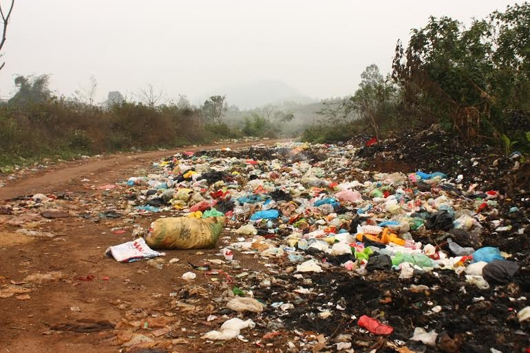 Rác nằm ngổn ngang trên đường, lấn hết một nửa đường đi.