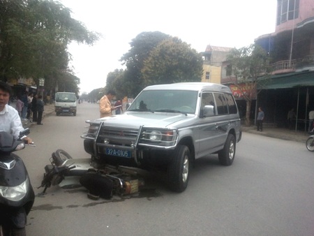 Xác định chiếc xe biển xanh đâm xe máy qua đường - 1 Hiện trường chiếc xe biển xanh nuốt xe máy khiến người đàn ông gần 60 tuổi gãy chân.