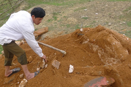 Anh Ngọ đang đào bới tảng đá lớn được cho là nằm dưới cạnh ngôi mộ.