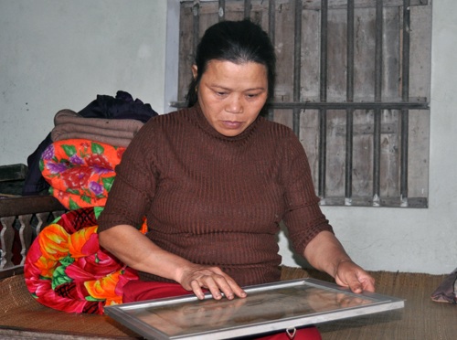 Chị Trần Thị Ninh bên tấm bằng Tổ quốc ghi công của chồng mình.