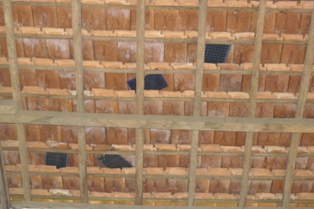 Trên mái ngói của ngôi trường cũ những tấm bảng đen được dùng che chắn những lỗ hổng...