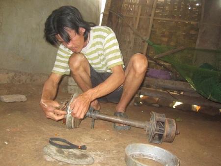 Một người dân sửa mô tơ điện cù để tìm nguồn chiếu sáng dù rất nguy hiểm và bất tiện. 