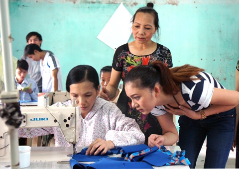 Bích Trâm tò mò xem những đường chỉ của những người khuyết tật đang thực hiện.