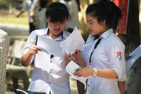 Thí sinh tại điểm thi trường THPT Huỳnh Thúc Kháng trao đổi lại đề thi. (Ảnh: Doãn Hòa)