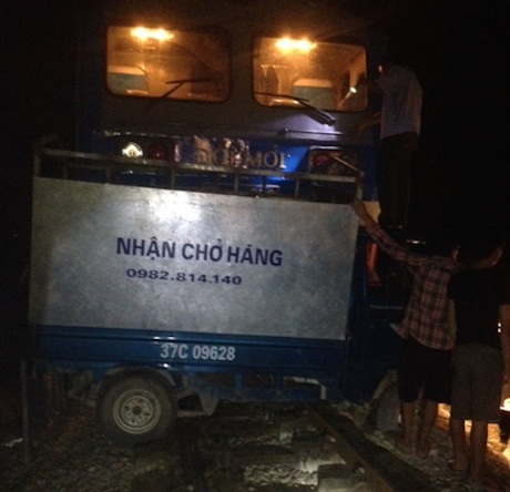 Hiện trường vụ tai nạn chiếc xe tải nhỏ bị tàu đâm nằm ngang trên đường sắt.
