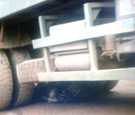 Hiện trường chiếc xe máy bị xe tải chở đá cuốn vào gầm.