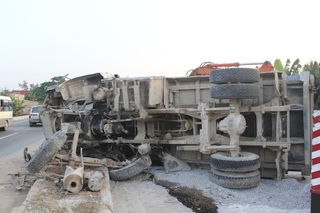 Chiếc xe tải không làm chủ được tay lái đâm và lật nhào trên giải phân cách. 