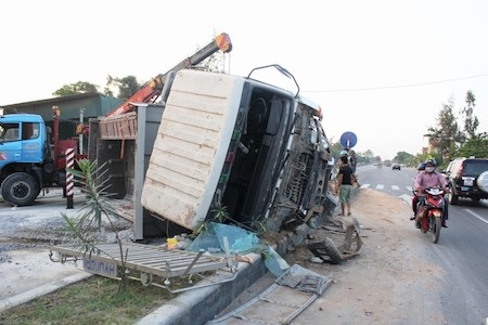 Chiếc xe tải không làm chủ được tay lái đâm và lật nhào trên giải phân cách. 