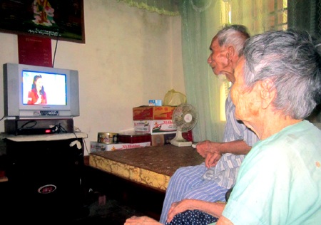 Cặp vợ chồng cao tuổi nhất Việt Nam cùng nhau xem ti vi, tin tức thời sự.