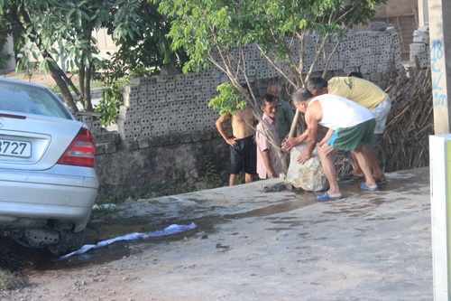 Xế hộp đâm phiến đá 100kg văng xa 20m - 2 Người dân vần phiến đá vừa bị ô tô tông