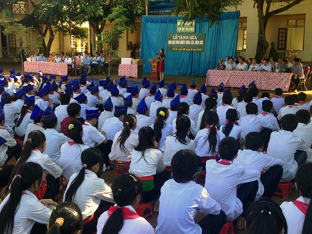 Các em học sinh H'Mông đón nhận những cuốn vở mới trước ngày khai giảng.