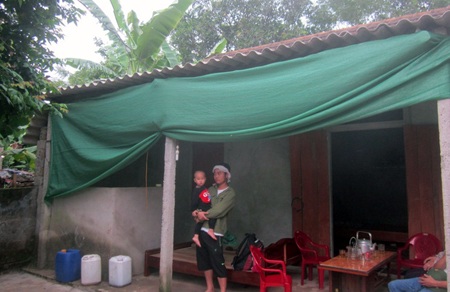 Anh Mạnh cùng đứa con đầu trước căn nhà tạm bợ của mình.