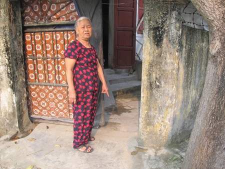 Cụ Võ Thị Phương chỉ nơi đã phát hiện cháu bé được người lạ để trước cổng nhà mình.