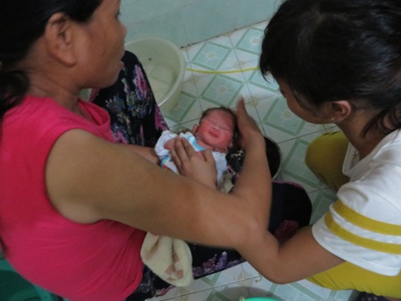 Cụ Võ Thị Phương chỉ nơi đã phát hiện cháu bé được người lạ để trước cổng nhà mình.