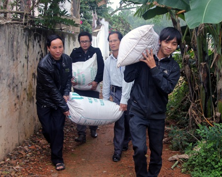 Các ban ngành hỗ trợ PV mang gạo vào nhà giúp bà Hương, cháu Tân.