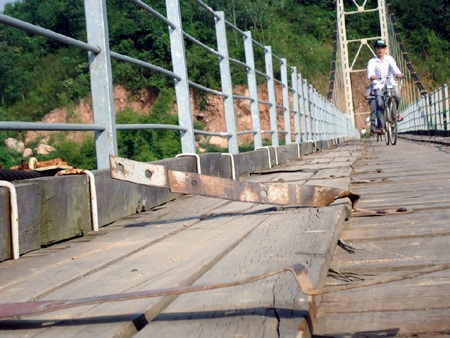 Hàng trăm đinh ốc vít bằng sắt trên mặt cầu đã bị mất cắp hư hỏng làm cho những khuy sắt bật lên.