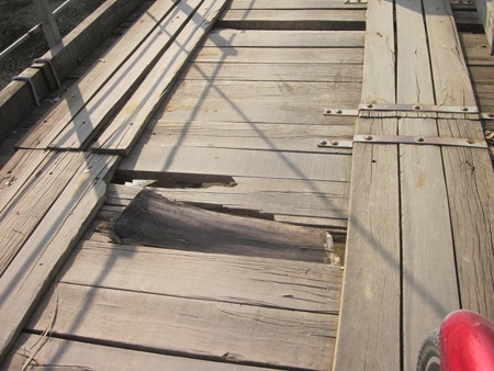 Hàng trăm đinh ốc vít bằng sắt trên mặt cầu đã bị mất cắp hư hỏng làm cho những khuy sắt bật lên.