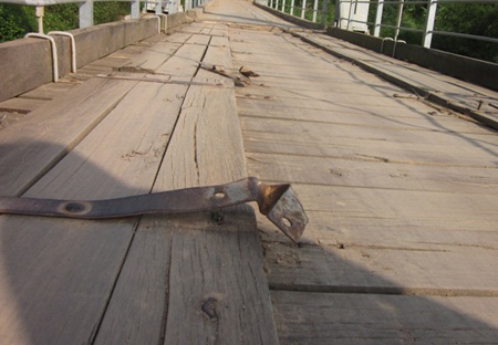 Hàng trăm đinh ốc vít bằng sắt trên mặt cầu đã bị mất cắp hư hỏng làm cho những khuy sắt bật lên.