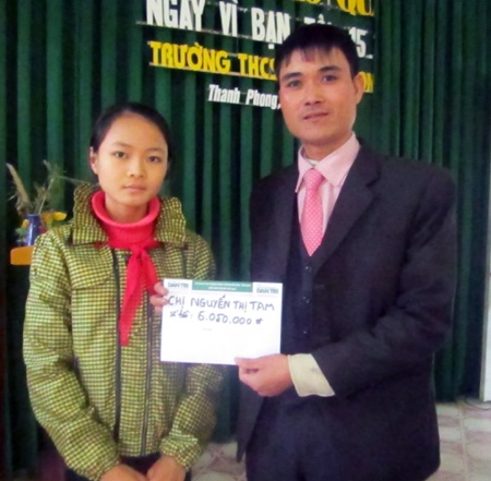 Thay mặt PV Dân trí, thầy Trần Đình Trung trao số tiền 6.050.000 đồng đến em Thương.