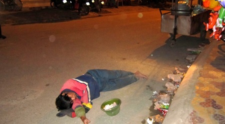 nằm bên vỉa đường ăn xin...