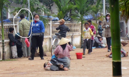 Một gã chăn dắt (trong ô khoanh tròn) đang nhắc nhở mấy người ăn xin....