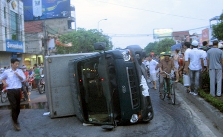 Xe tải tông xe máy rồi lật nghiêng giữa đường