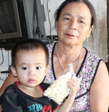 Đứa con 4 tuổi của chị Huệ cùng bà ngoại.