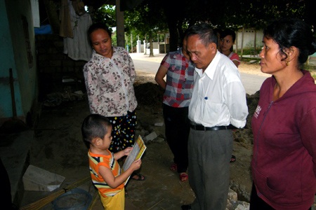 Bé Kheo Hoàng Anh đang đọc cuốn Tạp chí Thế giới trong ta trước sự chứng kiến của mọi người.