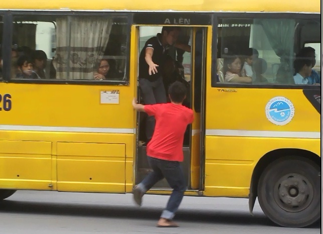 Giữa dòng xe cộ ken đặc, những hành khách vẫn đua nhau phi thân lên xe khách