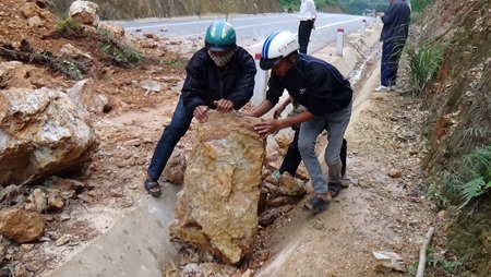 Sạt lở 15.000 m3 đất đá gây tê liệt tỉnh lộ - 2 Người dân hỗ trợ bốc một hòn đá để mở đường cho xe máy lưu thông tạm