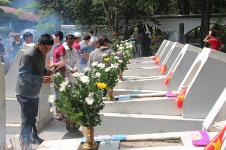 Những bông hoa và nén hương thắp lên mộ để tưởng nhớ các chị