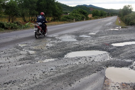 Xe quá tải "băm nát" quốc lộ - 7 Nhiều đoạn thảm nhựa bị dồn hẳn vào lề đường, hình thành những con chạch hết sức nguy hiểm.