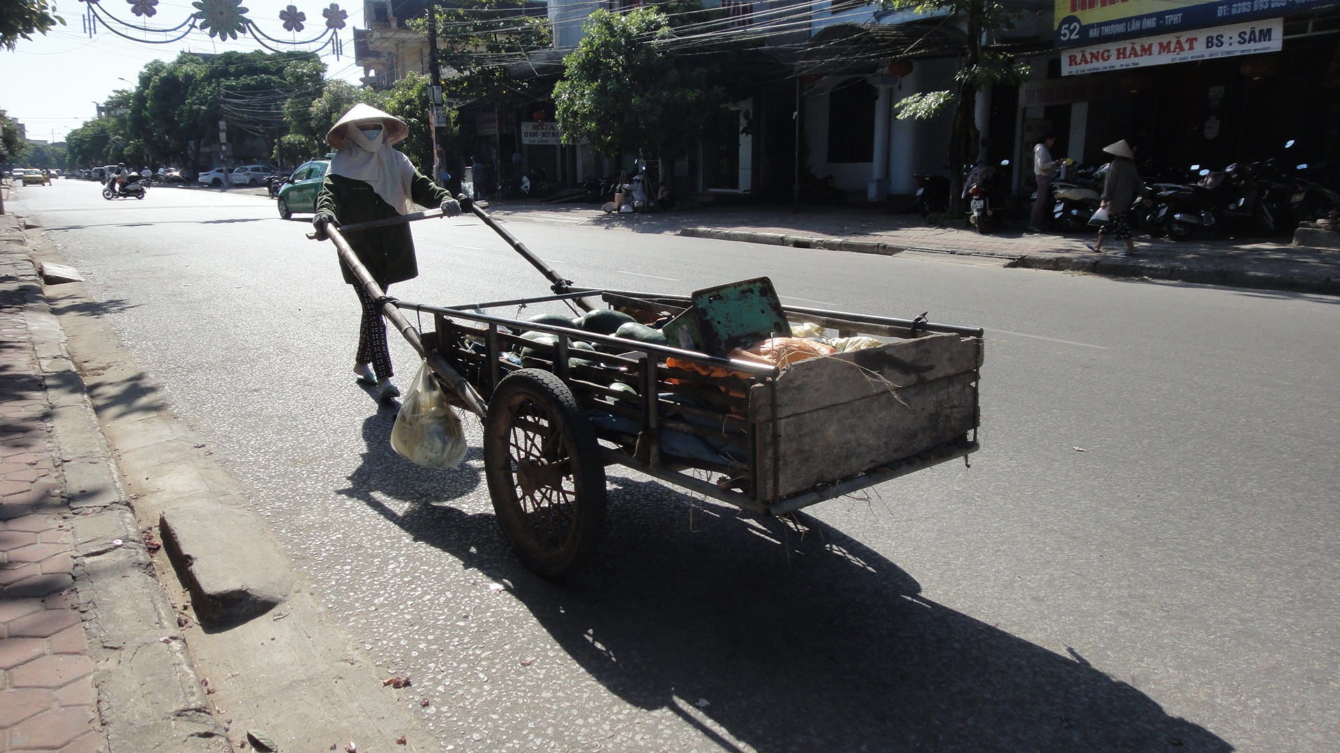  Vất
vả đẩy hàng ngược xuôi dưới cái nóng hầm hập của đường phố