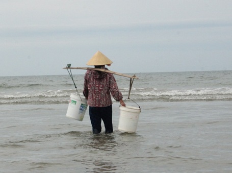 Chuyện người phụ nữ gánh nước biển đi bán - 1 Công việc hàng ngày của chị Hạnh là gánh nước từ biển vào bờ bán cho các quán hải sản.